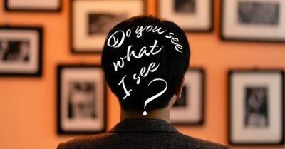 Person looking at art wall gallery with words "Do you see what I see?" written on top of person's head