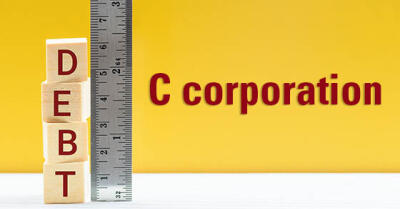 Block letters spelling "DEBT" leaning against a ruler, next to the words "C corporation"